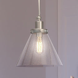 A Luxury Pendant lighting fixture with a glass shade hanging over a room from the Pawtucket Collection.