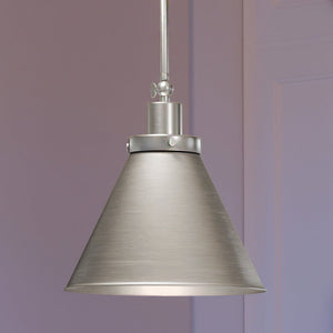 A unique lighting fixture, the Urban Ambiance UHP4003 Traditional Pendant from the Pawtucket Collection, hangs from a ceiling in a room.