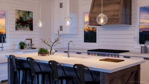 A beautiful kitchen with a large island and bar stools featuring the UHP4010 Minimalist Pendant 8.75''H x 8''W, Brushed Nickel Finish from the Canton Collection by