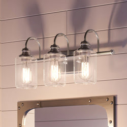 A beautiful Urban Ambiance vanity with three UHP4062 Vintage Bath Light 9.875''H x 23.375''W fixtures and a mirror.