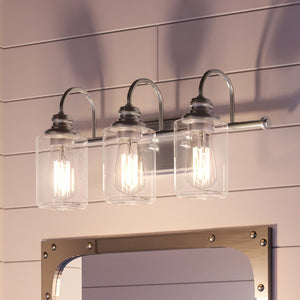 A beautiful Urban Ambiance vanity with three UHP4062 Vintage Bath Light 9.875''H x 23.375''W fixtures and a mirror.