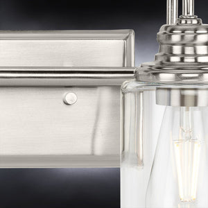 A gorgeous vintage bath light fixture with a unique brushed nickel finish and Hedland Collection, featuring clear glass bulbs.