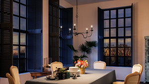 A dining room with a beautiful Urban Ambiance UHP4080 Traditional Chandelier 18''H x 30.125''W, Midnight Black Finish and luxurious Warwick Collection table and chairs.