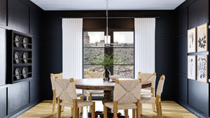 A dining room with beautiful black walls and a unique UHP4100 Modern Chandelier.