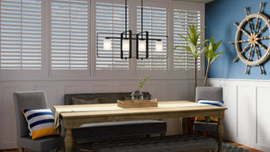 A dining room with a wooden table, gray chairs, and a bench exudes modern elegance—centered by the Urban Ambiance Broome UHP4109 XL Modern Chandelier in midnight black and accented by décor like a potted plant and decorative ship wheel on a blue wall.