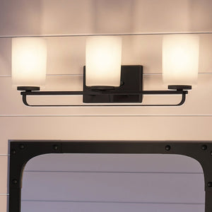 Three beautiful Broome Collection lighting fixtures with a mirror above them from Urban Ambiance.