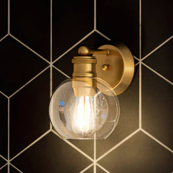 A black and white tiled wall with a gorgeous lighting fixture, the UHP4170 Vintage Wall Sconce 9.5''H x 6.5''W, Olde