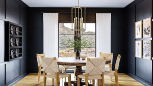 A dining room with black walls and the unique UHP4245 Contemporary Chandelier 31.375''H x 15''W, Olde Brass Finish, Parkes Collection by Urban