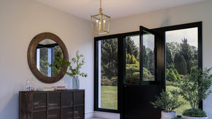 An entryway with a unique lighting fixture - the UHP4257 Traditional Chandelier 19.75''H x 10.875''W from Urban Ambiance, featuring a brushed bronze finish