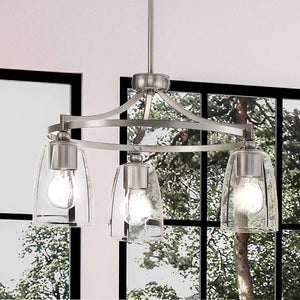 A beautiful lighting fixture, Three UHP4261 Traditional Chandelier with a gorgeous brushed nickel finish, from the Coronado Collection by Urban Ambiance, in a room with large windows.
