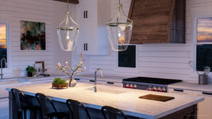A kitchen with a large island and bar stools, featuring the Urban Ambiance UHP4267 Traditional Pendant 23.375''H x 15.25''W lighting fixture from the Coronado
