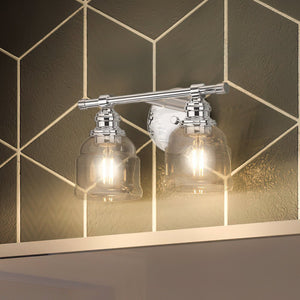 Gorgeous vintage bath lights by Urban Ambiance illuminate a bathroom with a unique tiled wall.