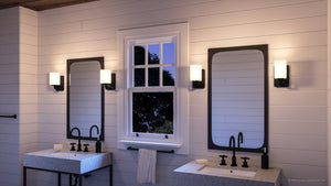 A luxury lighting fixture from the Louisville Collection by Urban Ambiance in a bathroom with two sinks and a mirror.