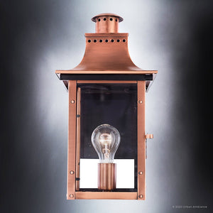 The Urban Ambiance UQL1413 Vintage Outdoor Wall Light from the Longview Collection, featuring a rustic copper finish, clear glass panels, and a visible bulb, is photographed against a gradient gray background to showcase the timeless charm of handcrafted outdoor lighting.