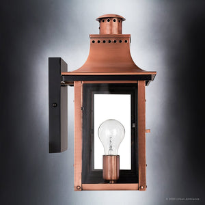 The Urban Ambiance UQL1413 Vintage Outdoor Wall Light from the Longview Collection features a handcrafted design with a rustic copper finish and black mounting plate. Measuring 15.3″ high by 7.75″ wide, this wall-mounted lantern showcases a glass panel door open to reveal a clear bulb inside, evoking the timeless charm of classic gaslight lanterns against a gradient gray background.