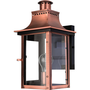 The Urban Ambiance UQL1413 Vintage Outdoor Wall Light from the Longview Collection features a handcrafted, rustic copper finish with clear glass panels and a visible bulb inside, mounted on a sleek black rectangular base for a classic gaslight lantern look. Measuring 15.3″ high by 7.75″ wide, this outdoor sconce combines timeless charm with modern craftsmanship.