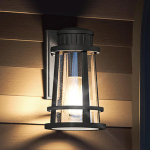 A gorgeous UQL1582 Tudor lamp, featuring a beautiful Natural Black Finish, from the Westcliffe Collection by Urban Ambiance on a wooden wall.