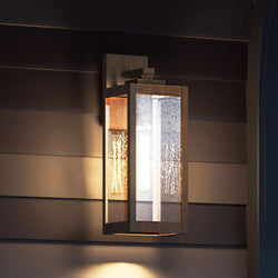 A beautiful 17''H x 6''W Modern Farmhouse Outdoor Wall Sconce, Bygone Bronze Finish, Quincy Collection by Urban Ambiance on the side of a house.