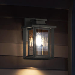 A luxurious UQL1642 Craftsman Outdoor Wall Sconce 11''H x 6.75''W, with a natural black finish, from the Peacehaven Collection, illuminating the