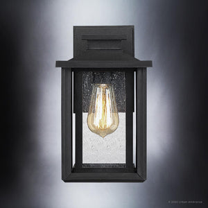 The Urban Ambiance UQL1642 Craftsman Outdoor Wall Sconce (11''H x 6.75''W) from the Peacehaven Collection features a natural black finish, marine-grade construction, and seeded glass panels with an exposed bulb.