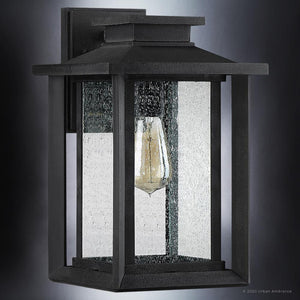 The UQL1643 Craftsman Outdoor Wall Sconce by Urban Ambiance, from the Peacehaven Collection, features marine-grade black metal, clear seeded glass, and a classic lantern design in a 14''H x 8.75''W size.