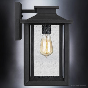 The Urban Ambiance UQL1643 Craftsman Outdoor Wall Sconce features a natural black finish, clear glass panels, and a single exposed bulb. Part of the Peacehaven Collection with marine-grade construction. Size: 14''H x 8.75''W.