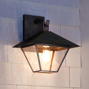 An UQL1653 Coastal Outdoor Wall Sconce, Bygone Bronze Finish, Seaford Collection by Urban Ambiance on a brick wall.