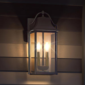The Urban Ambiance UQL1672 Eastbourne Collection vintage outdoor wall sconce, 18.5''H x 9''W with Estate Bronze finish and marine-grade construction, features clear glass and two visible bulbs for a timeless look on horizontal siding at night.