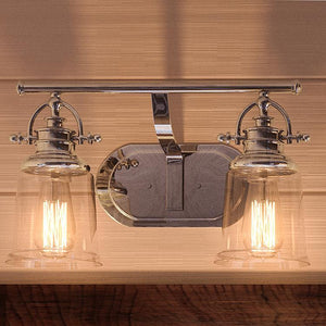 Two unique Urban Ambiance UQL2880 Industrial Bathroom Vanity Lights, 9.5"H x 16"W, with a Polished Chrome Finish from their Salford Collection hanging on a wooden