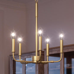 A beautiful and unique Urban Ambiance UQL3799 Modern Farmhouse Chandelier with an Olde Brass Finish hangs in a dining room.