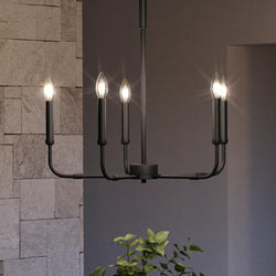 A beautiful UQL3803 Modern Farmhouse Chandelier, with a Matte Black Finish from the Bideford Collection, hanging in a room with a potted plant.