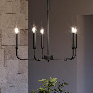 A beautiful UQL3803 Modern Farmhouse Chandelier, with a Matte Black Finish from the Bideford Collection, hanging in a room with a potted plant.