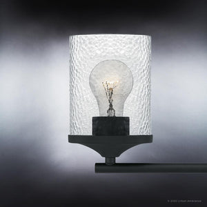 A beautiful UQL3818 Modern Farmhouse Bath Fixture with a glass shade on a black background from the Bideford Collection by Urban Ambiance.