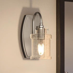 A beautiful UQL3975 Modern Farmhouse Wall Sconce lighting fixture with a glass shade, part of the Wrexham Collection by Urban Ambiance.