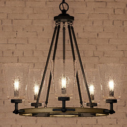 A beautiful Urban Ambiance UQL4061 Farmhouse Chandelier with four glass shades hanging in front of a brick wall.