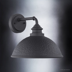 The Urban Ambiance UHP1177 Hammered Outdoor Wall Light from the Firenze Collection features a matte midnight black finish and an industrial design, with a round hammered metal shade, beautifully showcased against a gradient gray background.