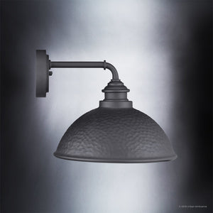 The Urban Ambiance UHP1177 Hammered Outdoor Wall Light from the Firenze Collection features a matte midnight black finish and a dome-shaped, hammered metal shade that highlights its striking industrial design against a gradient grey background.