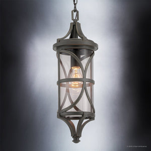 The Urban Ambiance UHP1182 Rustic Outdoor Pendant Light from the Brussels Collection features a modern design with a die-cast aluminum and glass construction, an exposed bulb, and is finished in Olde Bronze. Measuring 22″ x 7-1/2″, this fixture is suspended by a chain against a gradient gray background.