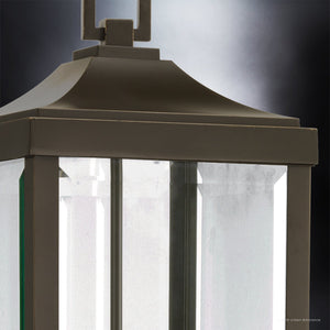 Close-up of the Urban Ambiance UHP1190 Colonial Outdoor Post / Pier Light from the Calderdale Collection, featuring an Olde Bronze finish and clear beveled glass panels, illuminated against a dark, blurred background.
