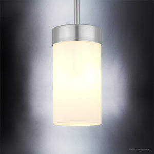 The UHP2307 Transitional Pendant Light from the Madison Collection by Urban Ambiance features a sleek cylindrical design with a polished chrome finish and an etched white glass shade, beautifully illuminated against a gradient gray background.