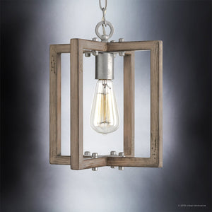 The UHP2743 Modern Farmhouse Pendant Light from Urban Ambiance’s Brighton Collection features a galvanized steel finish and a 12-1/4″ x 10″ wooden rectangular frame with an exposed bulb, suspended by a chain against a soft gray gradient background—blending rustic farmhouse charm with contemporary sophistication.