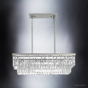 The Urban Ambiance UHP2883 Cosmopolitan Chandelier from the Lille Collection features a rectangular design with multiple rows of prismatic glass crystal prisms and an Antique Silver finish metal frame. Measuring 11″ x 33-7/8″, it is suspended by two rods from a ceiling mount against a neutral background.