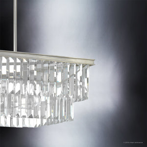 Close-up of the UHP2885 Cosmopolitan Chandelier from Urban Ambiance’s Lille Collection, featuring a modern rectangular prismatic clear glass design with two tiers, an antique silver metal frame, and a suspension rod, set against a gradient gray background. This 11″ x 20-1/8″ piece exemplifies luxurious decorative lighting with its refined style and sparkling clarity.