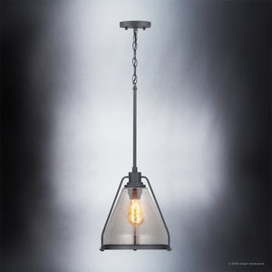 The UHP2993 Industrial Pendant Light from the Rochdale Collection by Urban Ambiance features a clear, triangular seeded glass shade with an exposed bulb and charcoal finish, suspended by a black metal chain against a gradient grey background for an effortlessly industrial-chic appeal.
